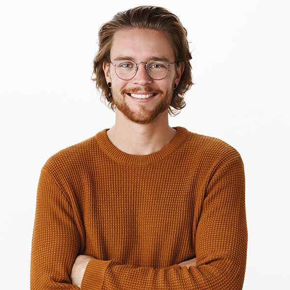 Waist-up shot of satisfied successful male programmer in glasses with beard holding hands crossed over chest in confident self-satisfied pose smiling pleased at camera against gray background.